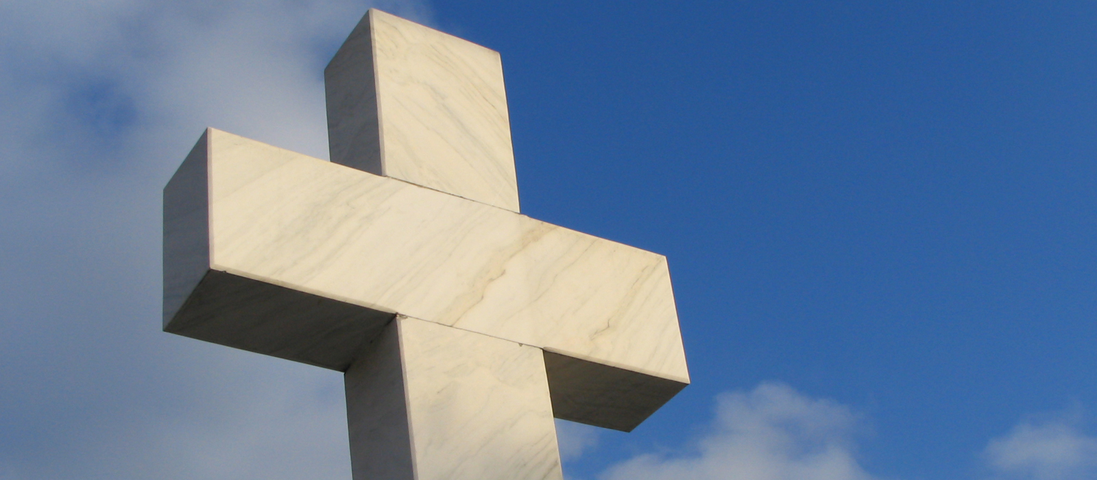 Large cross monument/statue erected outside.